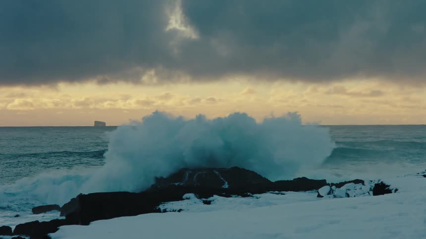 View of the sea with strong waves crashing against a rock