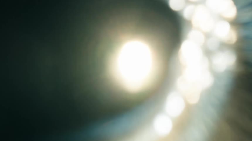 An abstract of a light fixture close up and moving around creating a flare of light