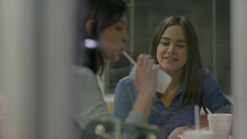 Two women sit at a table in a restaurant