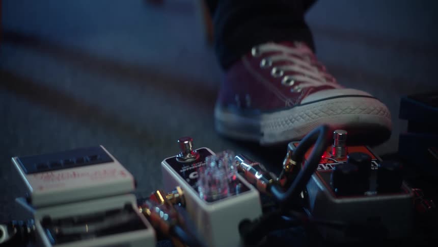 Closeup of a human foot pressing a button on a guitar device