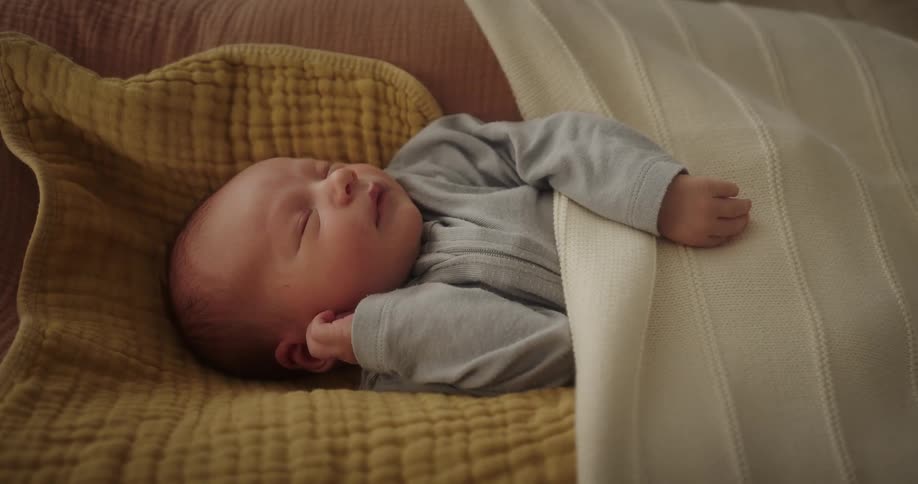 A baby sleeping in a comfortable bed