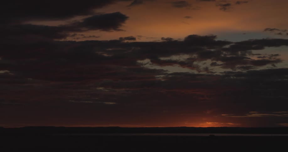 View of the orange sky with the sun rising behind the mountains