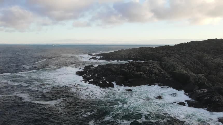 Aerial view of the sea with its strong waves crashing on a rocky area