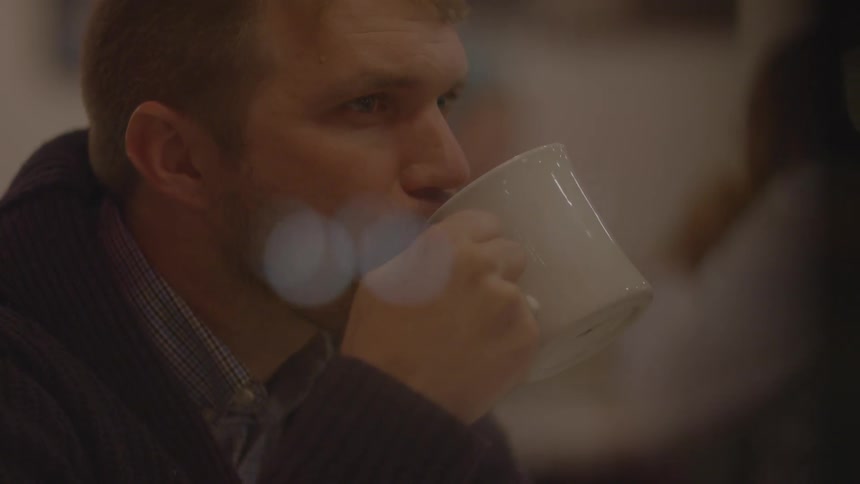 A man is drinking from a mug