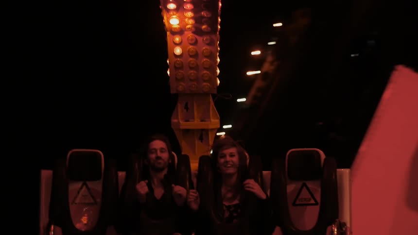 Couple riding an amusement park ride at night