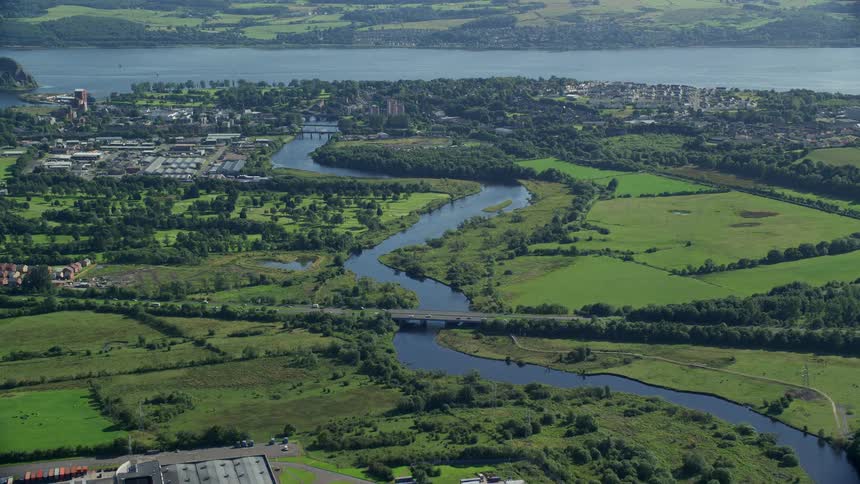Aerial view of a river crossing a small town next to a lake