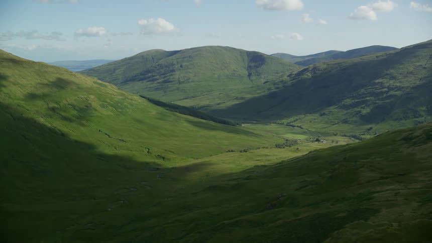 Thick grass covers rolling hills in the countryside