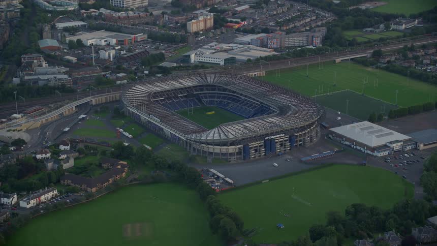 Aerial of a football stadium in an urban area at sunset