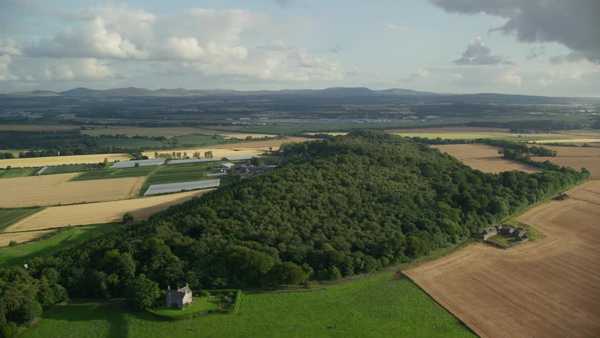 Aerial landscape of rural area with farms and lots next to forests and mountains during day time
