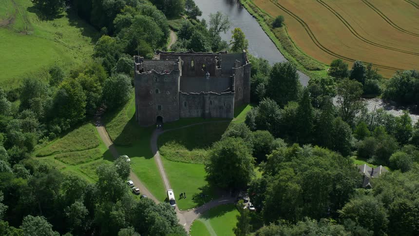 Drone view of an old castle in the middle of a rural area on a bright sunny day