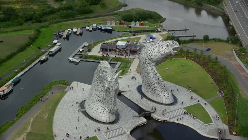 Aerial of two architectural horse heads built in art form with a waterway in between them with boats parked on one side