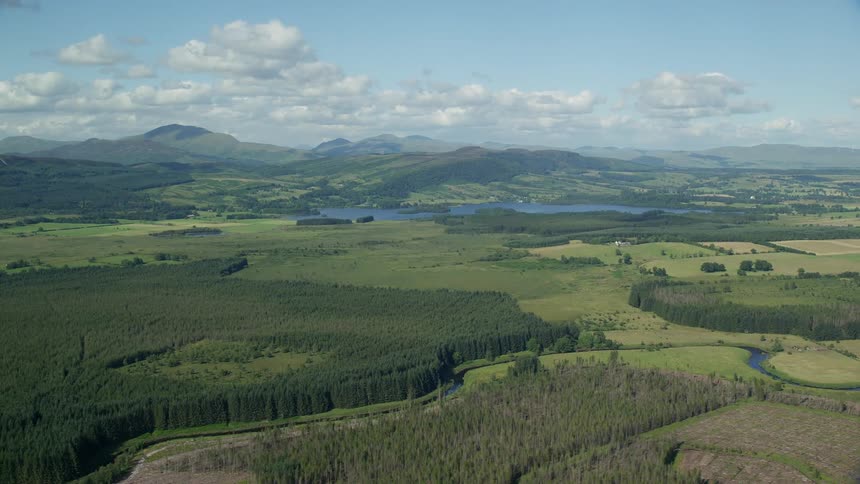 Aerial landscape view of forests and fields near a lake