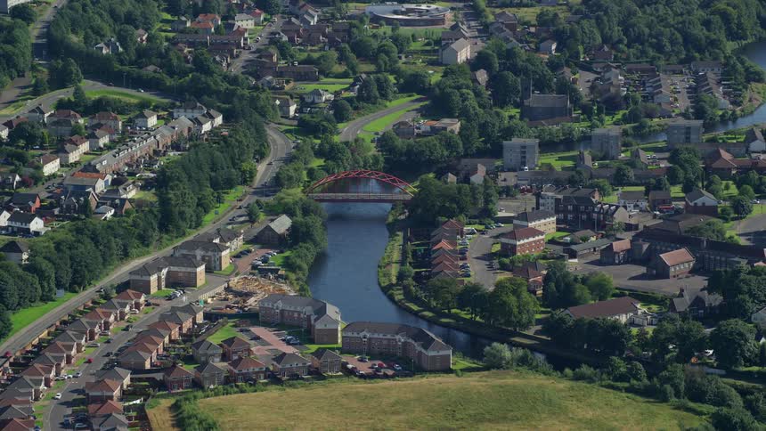 Aerial view of an arched bridge over a river in an european suburb