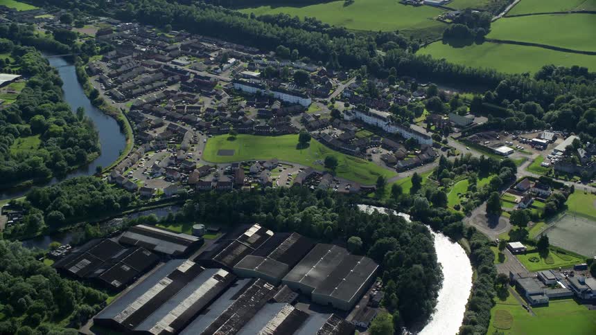Aerial view of a small urban town amidst vegetation and a small lake