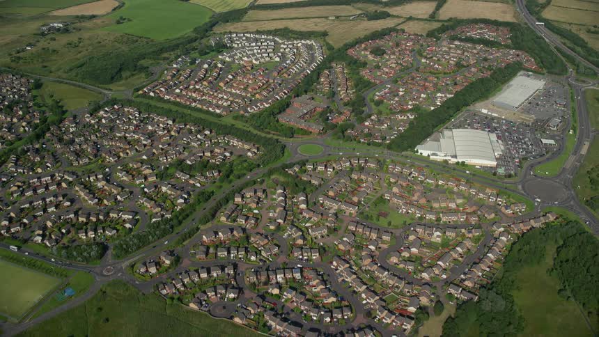 Aerial view of an urban city with abundant vegetation and pasture