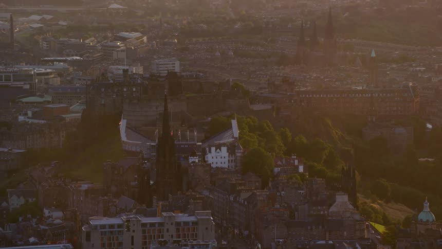 Aerial view of a castle on top of a hill in the city at sunset