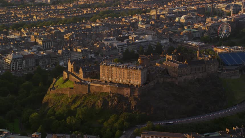 Aerial view of a public place with classical buildings on top of a mountain surrounded by an urban city during a late afternoon