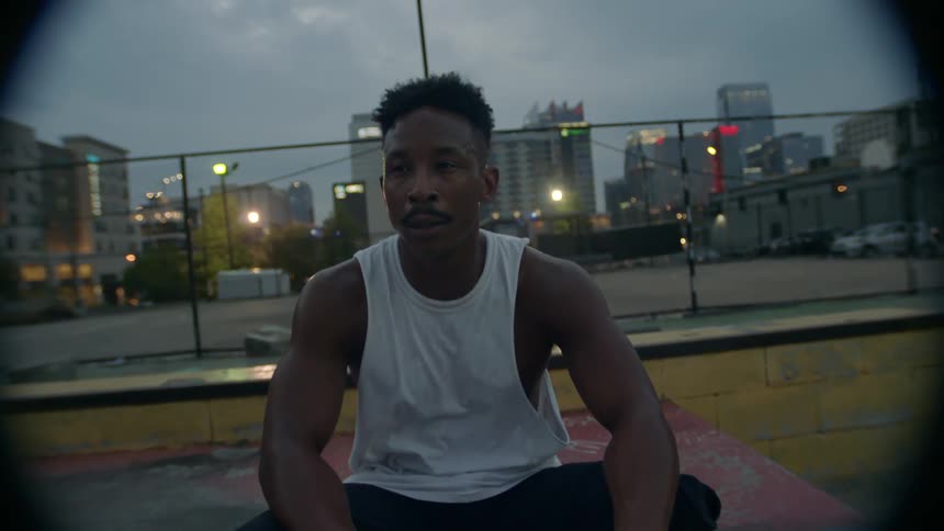 A man sits sweating as night falls
