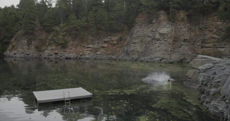 Three people jumping from above into a large pond