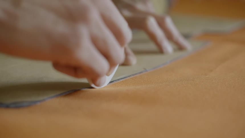 A man drawing patterns on a cloth placed on the table
