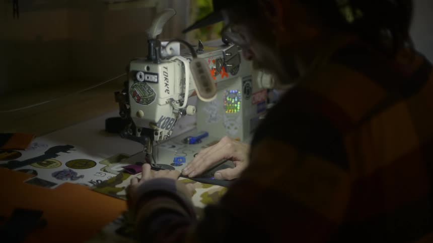 Man sewing a fabric on a sewing machine