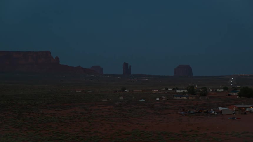Parked cars and buildings in a rural area at night
