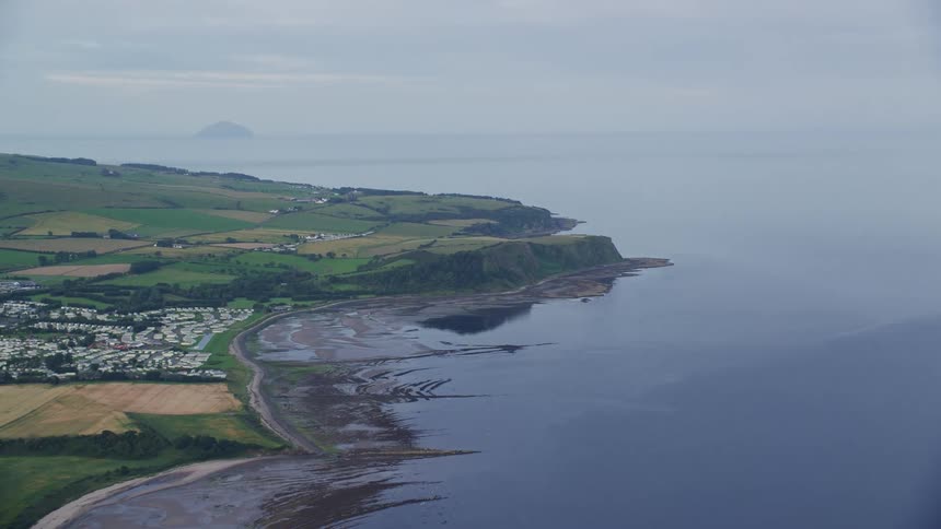 Aerial of a small coastal town with black sand