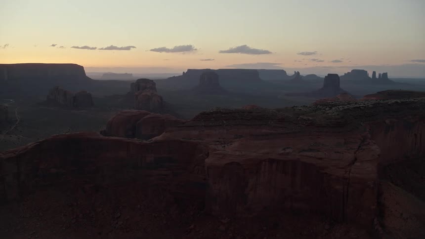 A desert region that has high rock formations in the background