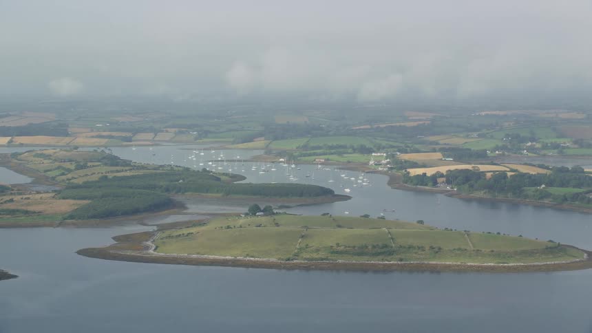 River winds through green islets on cloudy day