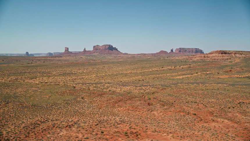 A desert region that has high rock formations in the background