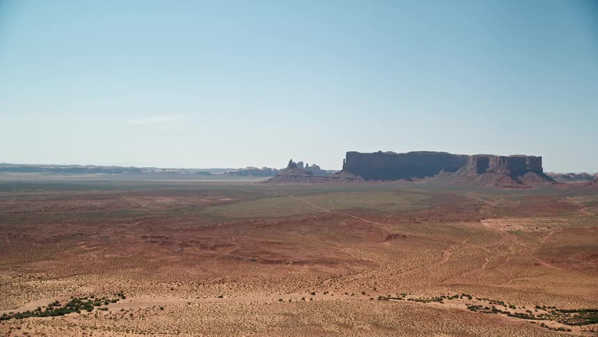 Aerial view of a desert with distant mesas in the horizon
