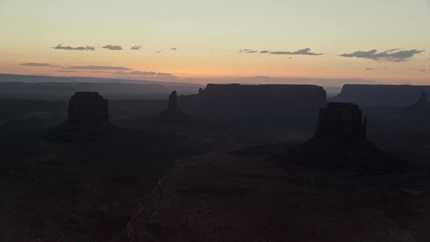 Aerial of a desert landscape with mountains at dusk