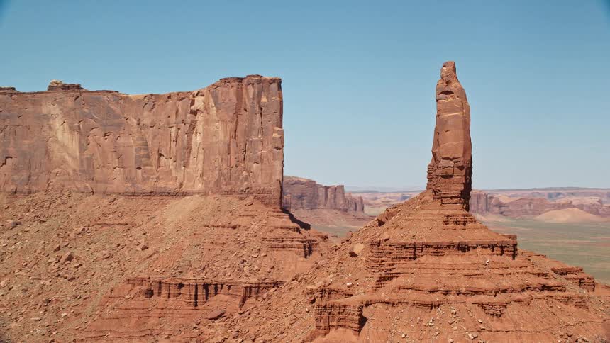 The sun shines upon red rock formations in the desert