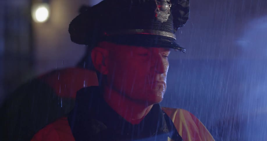 An officer is standing in the rain