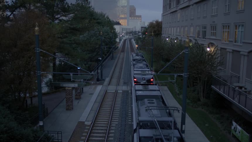 Train moving down the tracks in a city