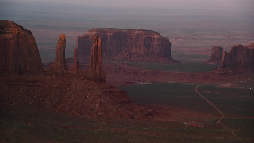 A desert with a dirt road in the middle and in the background there are mountains