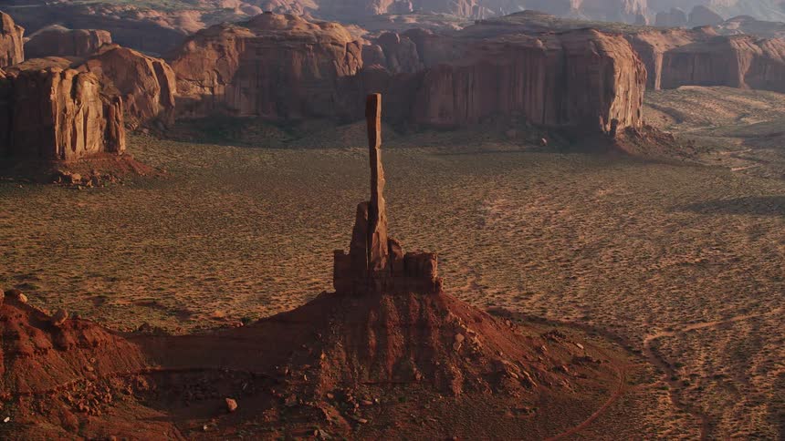 A birds eye view of a brown mountain range with canyons