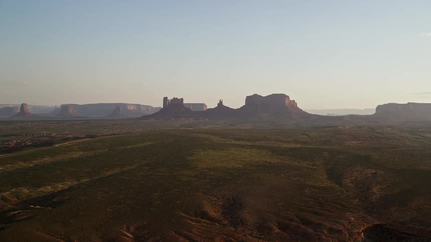 A desert with many stones and in the background a mountain rock formation