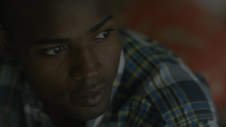 A man is looking down before looking to the side and getting up