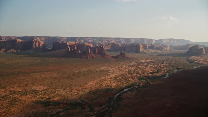 A desert with many stones and in the background a mountain rock formation