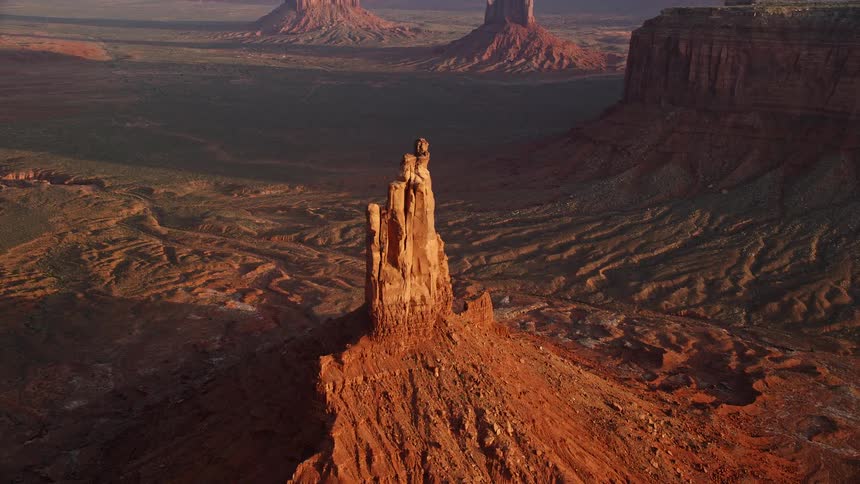 Aerial of butte formations on a desert landscape singling out one formation closely