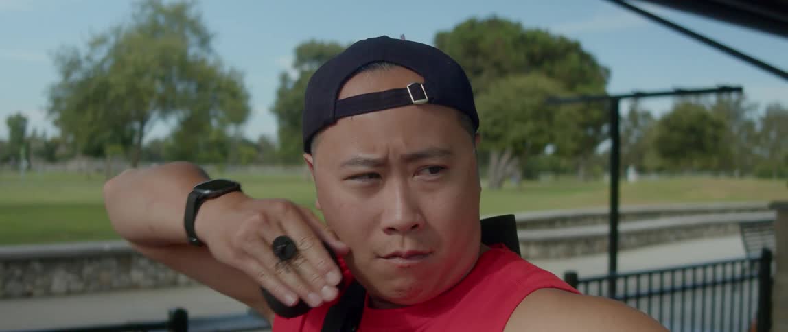 Young asian man picking up an arrow and shooting it with his bow
