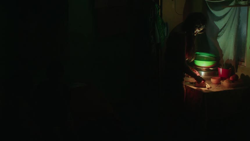 Young woman indoors lighting a candle with a match