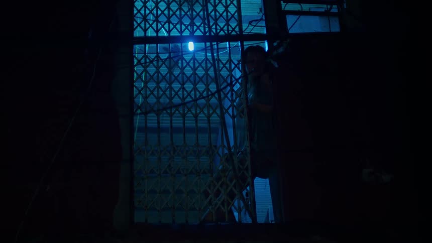 A girl is at the window watching the dark street