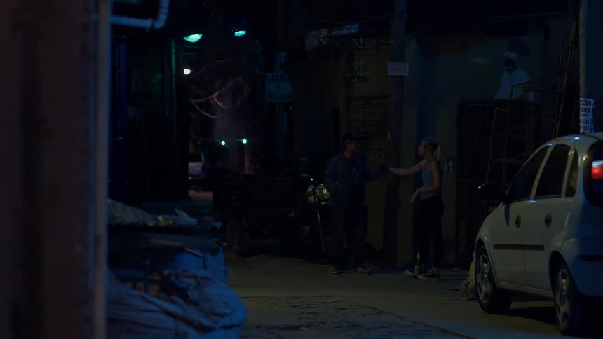 A man and woman interacting on the street where the woman pulls the man by the arm