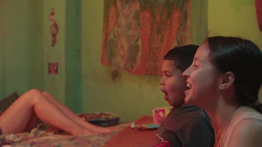 Siblings make fun faces in the bedroom