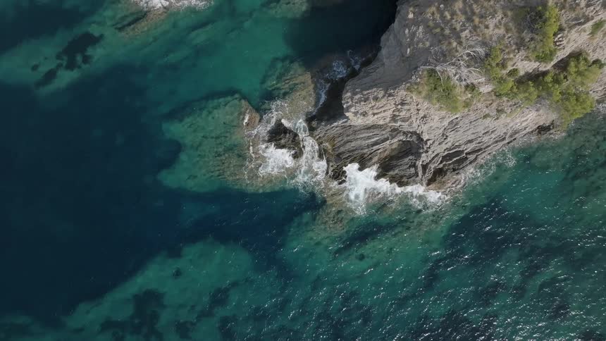 Top down aerial view of waves crasing on the coast