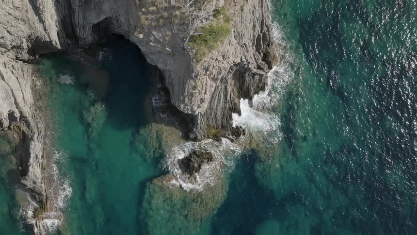 Aerial view of the coastline along a clear blue sea