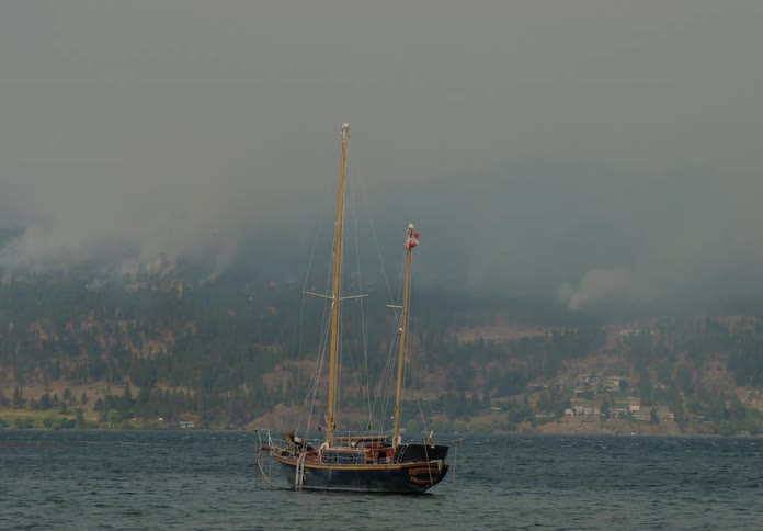 The sail boat is near the shore