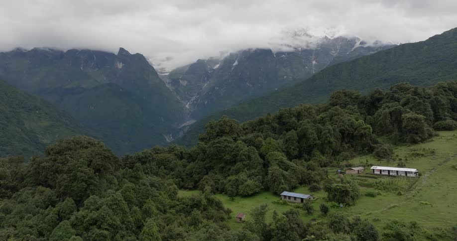 Aerial of the mountain with houses on top surrounded by forest
